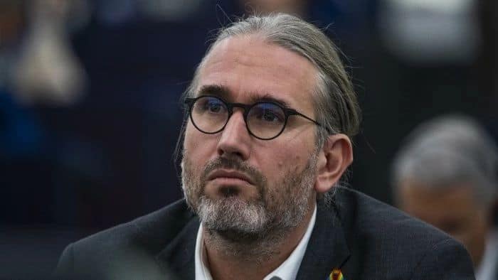 Serious man with glasses at a conference or meeting.