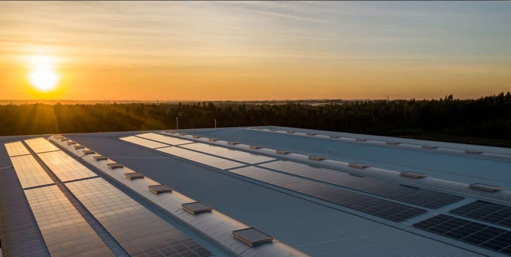 Solar panels on a rooftop at sunset, highlighting sustainable energy solutions and environmental ben.