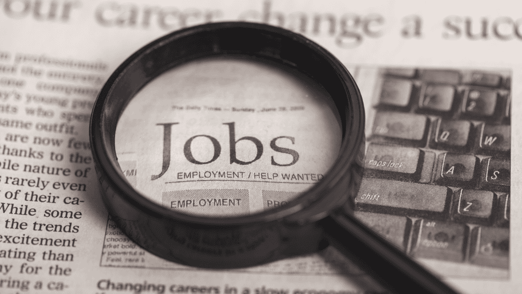 Magnifying glass over a job application form highlighting "Jobs" and employment options.